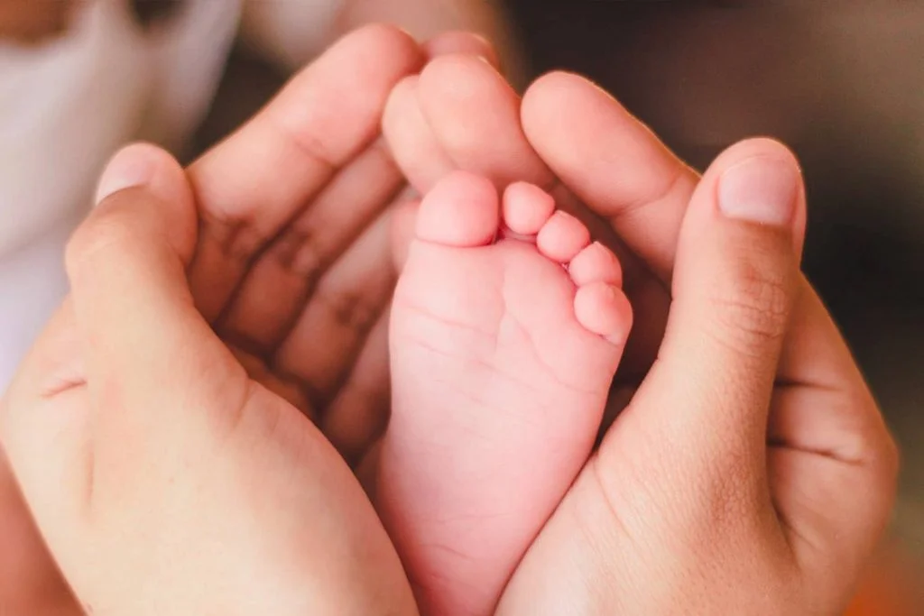 pied bebe dans les mains de sa maman